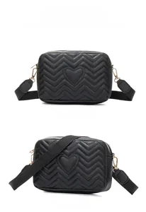 Front and side angles of black quilted camera bag with heart embroidery and wide strap