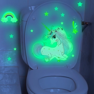 Luminous unicorn and stars wall stickers glowing in the dark on a white toilet