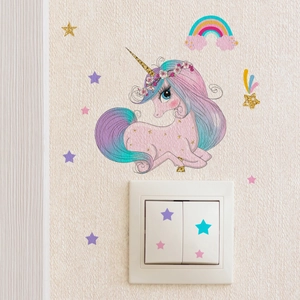 Glow-in-the-dark unicorn wall decal set applied on white textured wallpaper and light switch