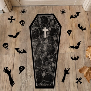 Detailed view of a black coffin-shaped Halloween mat with skull prints and a white cross