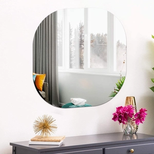 Detail of a large frameless oval mirror showing high clarity reflection in a modern room