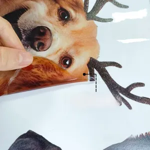Detail of double-sided golden retriever window sticker with festive reindeer antlers