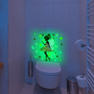 Leuchtender Wandaufkleber mit grün strahlender Fee und Schmetterlingen im dunklen Badezimmer