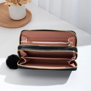 Black long wallet with double zippers, wave stitching, and a cute pompom keychain ornament