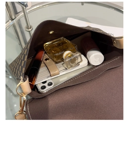 Vista interior del bolso bandolera vintage con lunares con teléfono y cosméticos