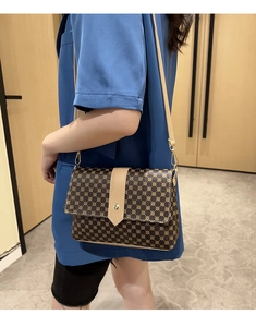 Detalle del bolso bandolera vintage con lunares, correa de cuero y hebilla dorada
