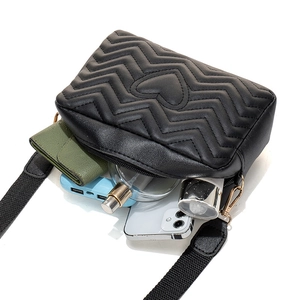 Minimalist black quilted crossbody bag with wave pattern and heart embroidery detailing