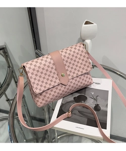 Detalle de bolso bandolera vintage rosa con lunares, cierre dorado y correa ajustable