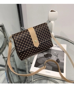 Elegante bolso bandolera retro de lunares sobre mesa de cristal con decorado