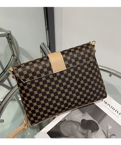 Detalle de bolso bandolera vintage con estampado floral, correa crema y cierre dorado