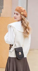 Mannequin portant un mini sac téléphone vintage en cuir noir avec chaîne dorée chic