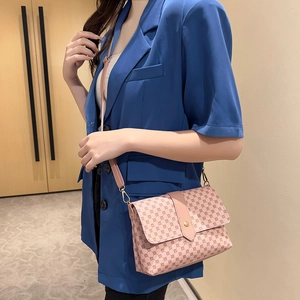 Bolso bandolera rosa con estampado geométrico y hebilla dorada sobre un blazer azul