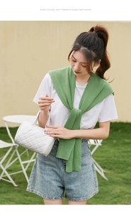 Close-up of white quilted boston bag with elegant diamond stitching and dual handles