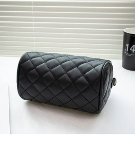 Close-up of black quilted Boston handbag with detailed diamond stitching and metal rings