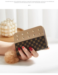 Détail du mini porte-monnaie à pois avec pompon décoratif et rivets dorés élégants
