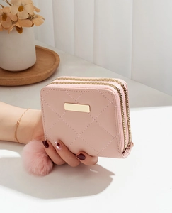 Vue détaillée du petit portefeuille rose matelassé avec double fermeture et pompon