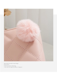 Détail d'un portefeuille en cuir rose matelassé avec pompon duveteux et logo en métal