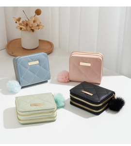 Détail de porte-monnaie en cuir PU matelassé avec doubles fermetures et pompons doux