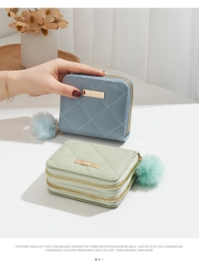 Détail de portefeuilles matelassés pour femmes avec double fermeture éclair et pompons