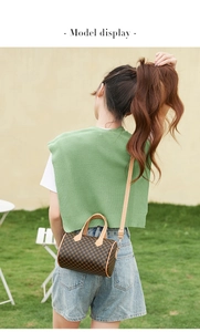 Outdoor model display of a vintage brown monogram cylinder boston bag with top handles