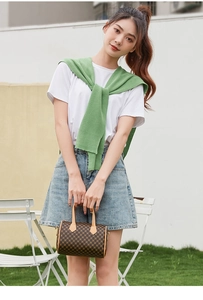 Outdoor shot of a woman carrying a mini Boston bag with vintage geometric plaid pattern