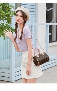 Outdoor model wearing a vintage printed Boston bag with pink straps and geometric pattern