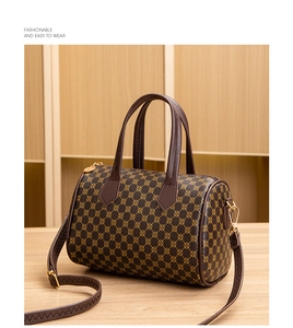 Detail of Boston cylinder bag with yellow polka dot prints and brown leather handles