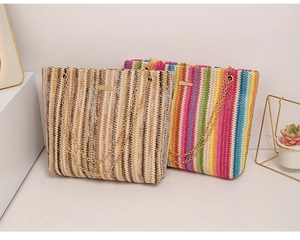 Detalle de textura de bolso tote de paja tejida arcoíris con cadena dorada elegante