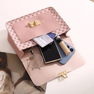 Pink crossbody bag with floral pattern and gold lock showing interior storage space