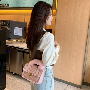 Pink printed crossbody bag with floral pattern and plush handle shown in a cafe setting