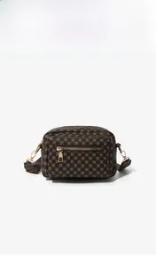 Detail of coffee crossbody camera bag with geometric patterns and golden zippers