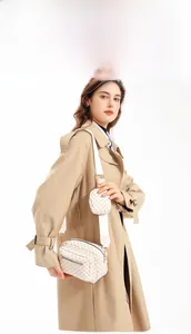 Close-up of beige crossbody camera bag with diamond pattern and detachable coin purse