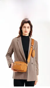 Brown crossbody camera bag with polka dot pattern and a small round coin purse attachment