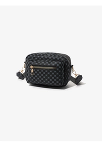 Detail of crossbody camera bag with black polka dot quilted pattern and gold zippers
