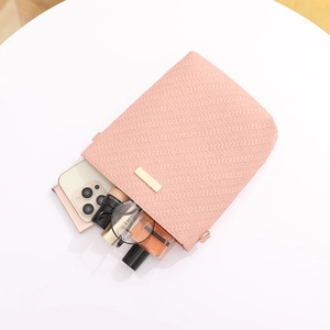 Pink woven texture bucket bag showing internal storage for phone and cosmetics
