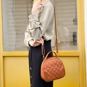 Quilted caramel leather handbag with diamond stitching and metal flower accent