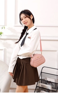 Detailed close-up of pink quilted crossbody bag with golden hardware and wide strap