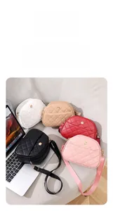 Detail of multi-color quilted crossbody bags with floral logos on a gray sofa