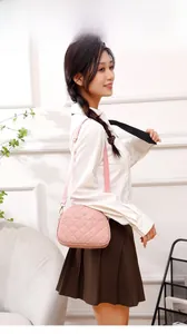 Quilted pink crossbody bag with flower clasp shown on model for daily lifestyle view
