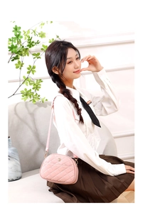 Detailed view of a pink quilted floral bag featuring a gold flower clasp and slim strap