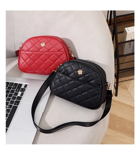 Detail of quilted crossbody bags with gold flower buckles in red and black colors