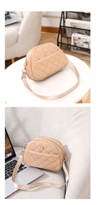 Detailed view of beige quilted crossbody bag with golden flower logo and wide strap