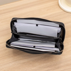 Women's black faux leather zipper wallet with multiple card slots on wooden table