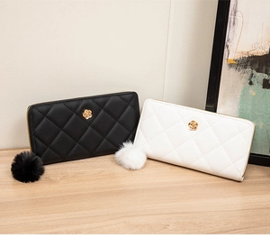 Detail of long quilted PU leather wallets with gold camellia and fur pompom charms