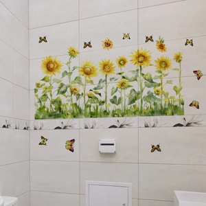 Detail of sunflower and butterfly wall stickers on a white tiled bathroom wall
