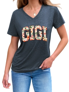Gros plan d'un t-shirt gris à col en V avec lettrage floral GIGI et texture du tissu