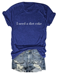 Détail du texte I Need a Diet Coke sur le tissu d'un t-shirt bleu à manches courtes