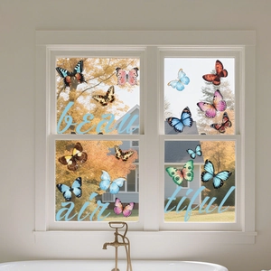 Colorful double-sided butterfly window stickers on a white glass frame with autumn view