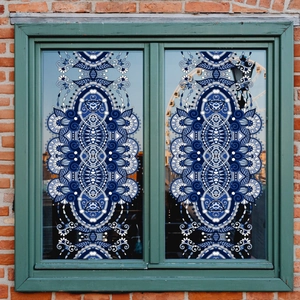 Elegant blue and white mandala window sticker on vintage green wooden frame