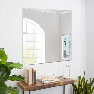 Frameless square mirror wall sticker on white wall above a wooden console table